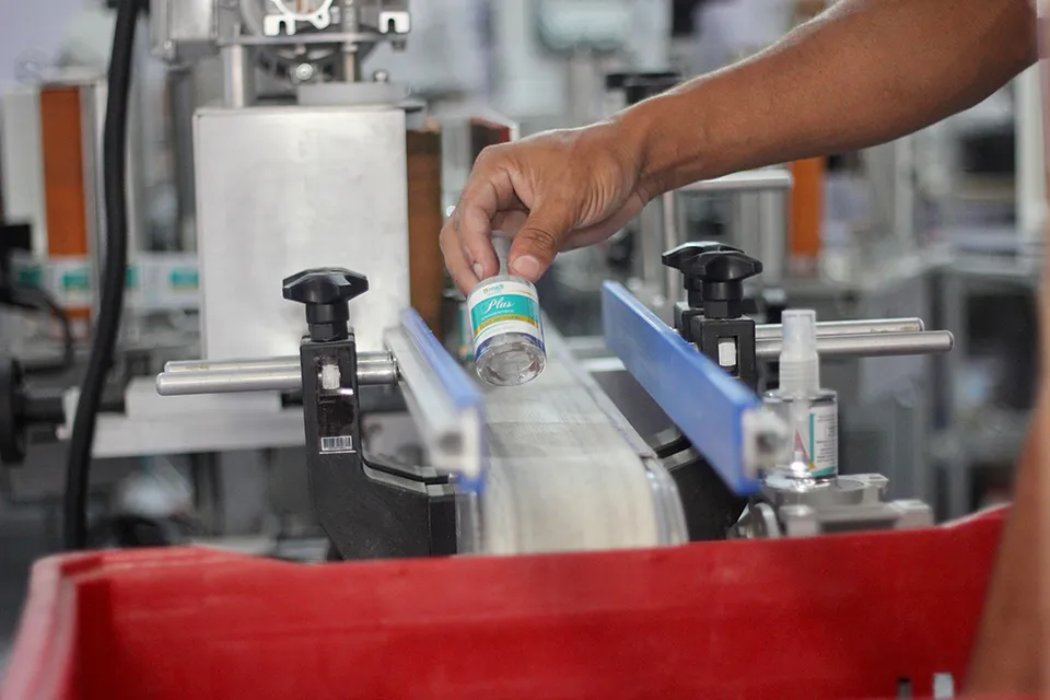 Frasco entrando na esteira de rotulagem da fábrica da Line
